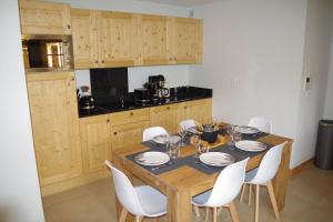 莱德萨阿尔卑斯Résidence : Le Crystal Chalet的厨房配有木桌和白色椅子