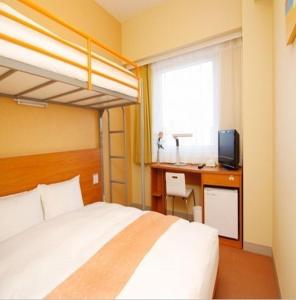 仙台IC仙台泉微笑酒店的一间卧室配有一张床和一张书桌及电视