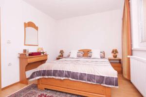 萨拉热窝Guesthouse Relax and Fly Sarajevo的一间卧室配有木床、桌子和镜子