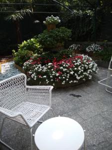 米兰马耳他酒店的白色的椅子和桌子以及一些鲜花