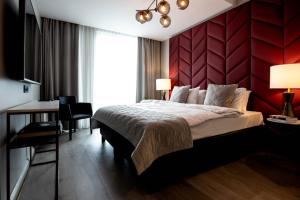 雷克雅未克Midtown Hotel的一间卧室设有一张大床和红色的墙壁