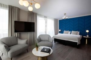 雷克雅未克Room With a View Hotel的一间卧室配有一张床、两把椅子和一台电视