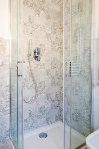 菲乌米奇诺FCO Luxury Apartments的带淋浴的浴室和玻璃门
