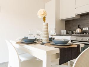 菲乌米奇诺FCO Luxury Apartments的白色的厨房,配有带花瓶的桌子