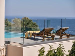 KoríthionThea lux natur villa的阳台配有两把椅子和一张桌子,位于屋顶