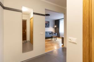 瓦尔米耶拉City center Gauja apartment的一个带镜子的走廊和一间客厅