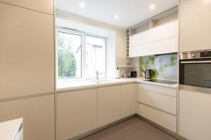 瓦尔米耶拉City center Gauja apartment的厨房配有白色橱柜和窗户。