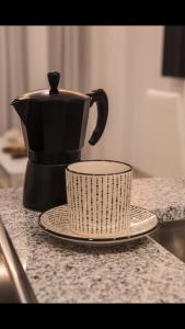 塔里法TURISMO LOS LANCES TARIFA( PARKING GRATUITO)的咖啡壶和柜台上的杯子
