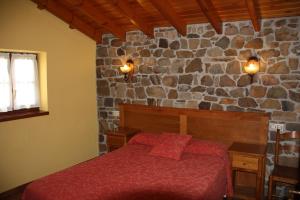 波拉-德拉维亚纳拉卡瑟纳德安特拉戈酒店的一间卧室设有一张床和石墙