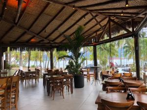 伊利亚贝拉Ilha Flat Apto 3207的餐厅设有木桌、椅子和许多窗户