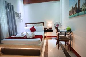 Pili伊丽莎白酒店 - 纳加的卧室配有1张床、1张桌子和1把椅子