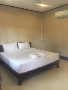东德岛肯萨瓦特乐比久旅馆的一间卧室配有一张床,上面有两条毛巾