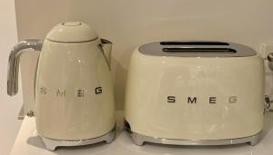 墨尔本Boutique Abode 314的两个白色烤面包机彼此坐在柜台上
