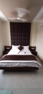 NavsāriHotel Shahi Darbar的一间卧室配有一张大床和大床头板