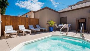 洛杉矶贝斯特韦斯特皇家宫殿酒店的后院设有游泳池、椅子和围栏