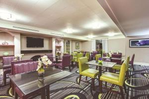 盖恩斯维尔Days Inn by Wyndham Gainesville Florida的餐厅设有桌椅和平面电视。