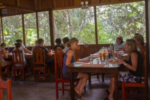 马尔多纳多港塔波帕塔河住宿加早餐旅馆的一群坐在餐厅桌子上的人