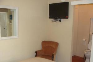 德班考伊斯科纳尔住宿加早餐旅馆的一间房间,墙上有椅子和电视