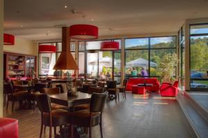 温特贝格温特贝格度假村酒店的餐厅设有红色的椅子和桌子以及窗户。