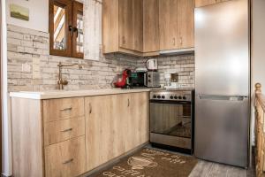 皮特斯迪亚Chalkidιό的厨房配有木制橱柜和不锈钢冰箱。