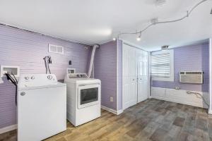 新奥尔良Newly-renovated Comfortable Studios Near All NOLA Hot Spots的厨房拥有紫色的墙壁,配有洗衣机和烘干机