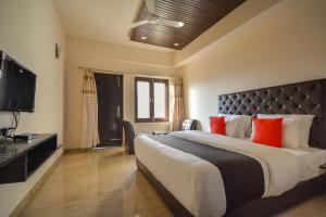 KuniharNakshatra Resort的一间卧室配有一张带红色枕头的大床
