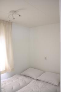 艾默伊登Chalet Charlee的白色的卧室设有床和窗户
