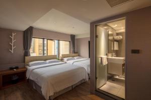 台北悠趣旅店的酒店客房,设有两张床和镜子
