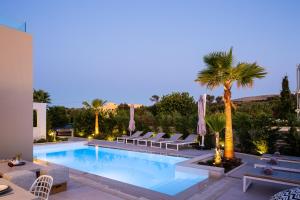 卢特拉Vasilios Villa, Luxury Escape, By ThinkVilla的一个带躺椅的游泳池,并种植了棕榈树