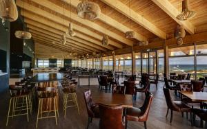 普拉亚德尔瑞伊West Cliffs Ocean and Golf Resort的餐厅设有木制天花板和桌椅