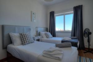 埃斯托利尔Sunny Monte Estoril的酒店客房设有两张床和窗户。