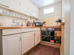 蒙默思7 Glendower Street的厨房配有白色橱柜、水槽和炉灶。