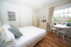 温彻斯特The Bugle Inn Twyford的卧室配有白色的床、桌子和窗户。