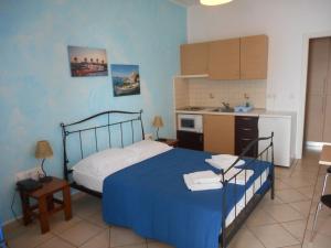 阿齐亚·佩拉加·基西拉潘托尼亚公寓的一间带蓝色床的卧室和一间厨房