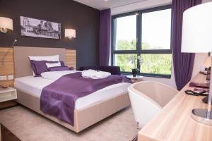 盖尔森基兴海纳公园酒店的一间卧室配有一张床、一张书桌和窗户。
