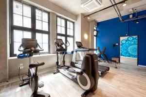 柏林加泰罗尼亚柏林米特酒店的一间健身房,里面设有心肺功能训练器材,房间拥有蓝色的墙壁
