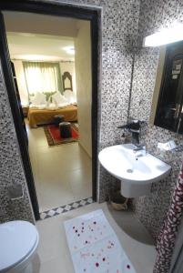 瓦尔扎扎特玫瑰谷酒店的一间带水槽和镜子的浴室以及一间卧室
