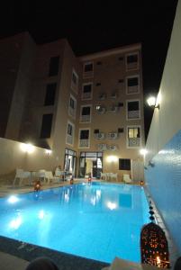 瓦尔扎扎特玫瑰谷酒店的一座游泳池,在晚上在建筑物前