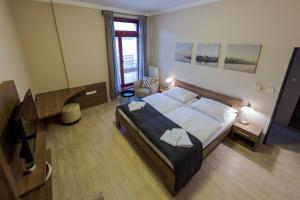 波杰布拉迪Penzion Apartmány Resident的一间卧室配有一张大床和电视