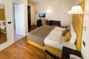 马尔切西内梅里蒂安娜酒店的酒店客房设有一张大床和一张书桌。