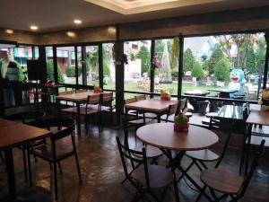 梭桃邑บ้านทิพรัตน์ สัตหีบ的餐厅设有桌椅和大窗户。