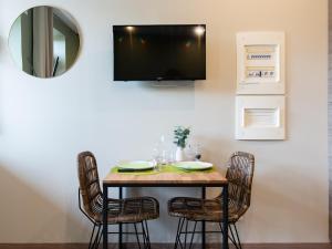 布雷斯地区布尔格Legend- Parking privé Gratuit- Terrasse privée- Wifi - Convert - Alimentec的餐桌、椅子和墙上的电视