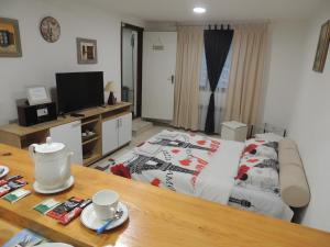 萨拉热窝APARTMAN AZRA的客厅配有一张床和一张桌子及四柱床