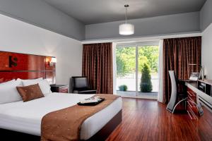 戈德里奇塞缪尔精品酒店的配有一张床、一张书桌和一扇窗户的酒店客房