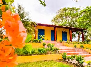 Los SantosFinca Pamel的黄色的房子,设有蓝色的门和楼梯
