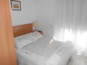 San Vicente de Castellet卡拉艾琳旅馆的卧室内的白色床、白色床单和枕头