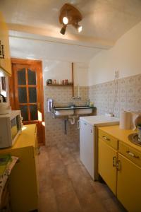 莫尔Kerti lak的厨房设有黄色和白色的橱柜和天花板