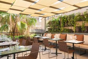马略卡岛帕尔马Hotel Antigua Palma - Casa Noble的一间设有桌椅的餐厅,种植了植物