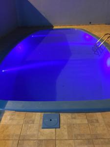 伊瓜苏Visk Palace Hotel e Restaurante的蓝色游泳池,铺有瓷砖地板
