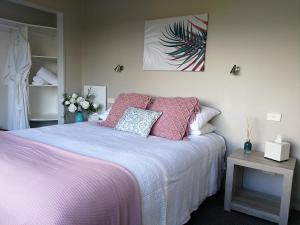 Awatuna山间小屋乡村民宿的一间卧室配有一张带粉色床单和枕头的床。